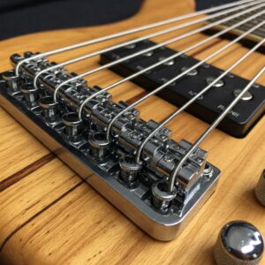 Close-up of the bridge on a 12 string electric bass, illustrating the string anchoring system.