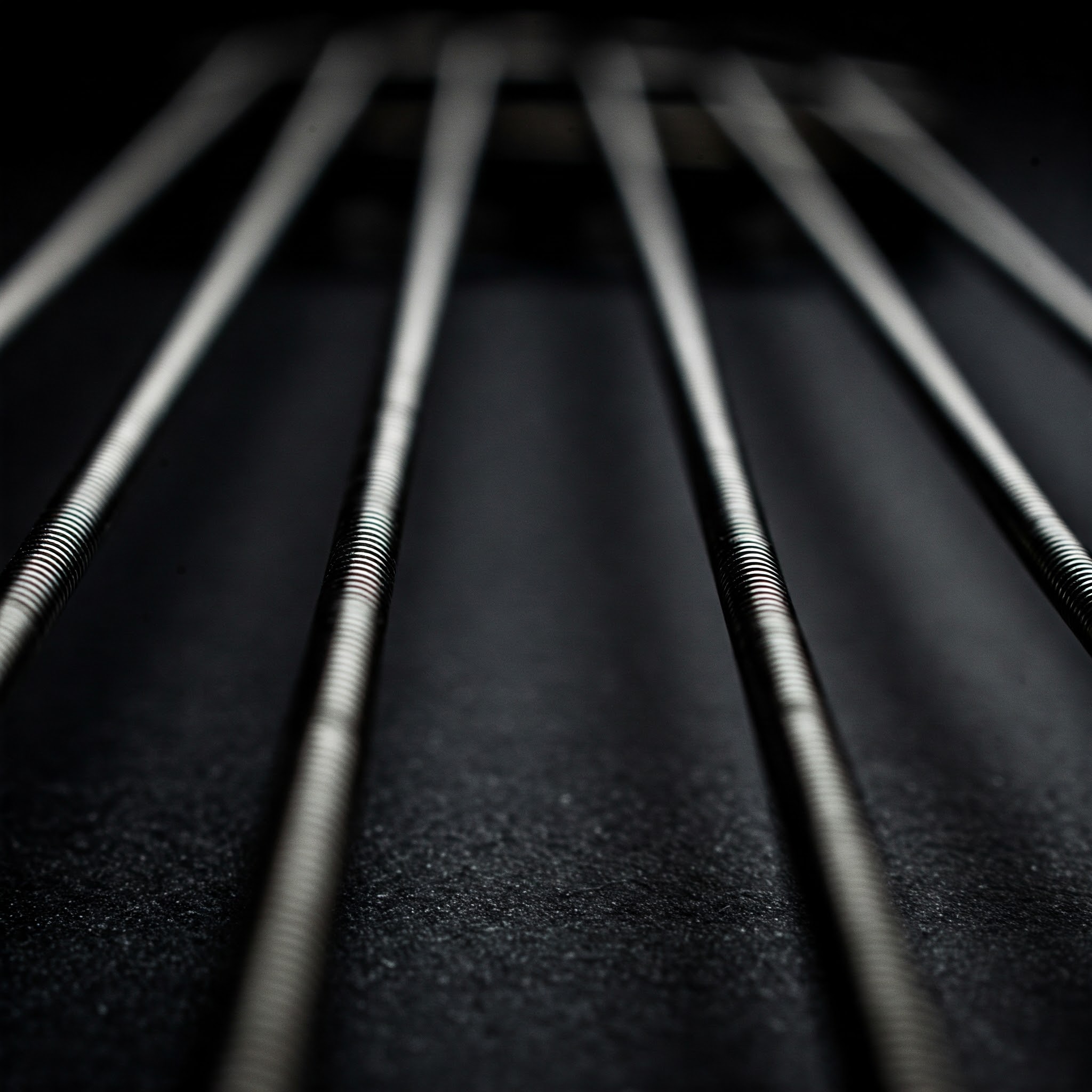Close-up view of flatwound bass guitar strings, highlighting their smooth surface.
