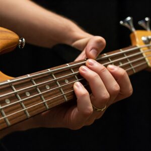 "Hand playing the neck of one of the best 5 string bass guitars."