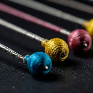 Detail of rotosound bass strings ends, highlighting the color-coded silk for easy identification.