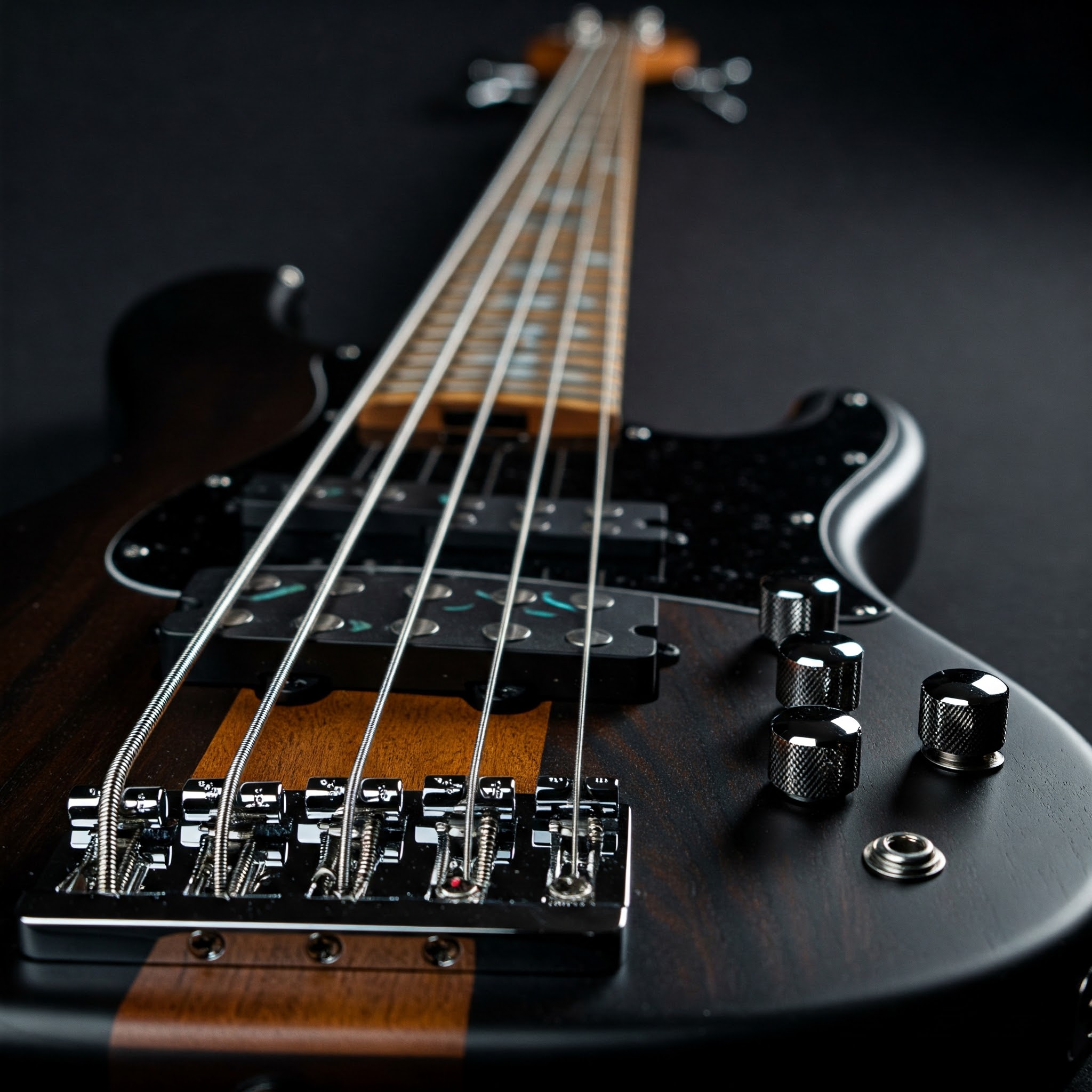 A close-up view of a short scale 5 string bass guitar, highlighting its compact design and five strings.