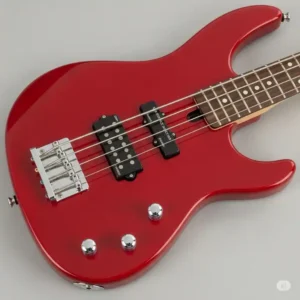 Detail shot of a red Cort Action bass series guitar, highlighting its ergonomic body shape and versatile pickup configuration, ideal for beginner and intermediate players.