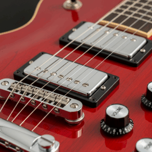 The dual humbucker pickups and tune-o-matic bridge on a Rogue Rocketeer Electric Guitar.
