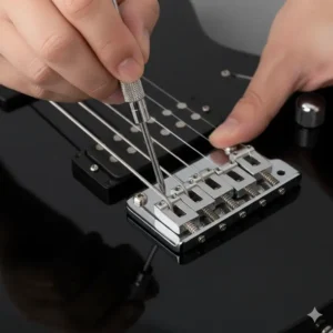 A person's hand using a small screwdriver to adjust the height of a guitar bridge saddle, demonstrating a key part of setting up a guitar.