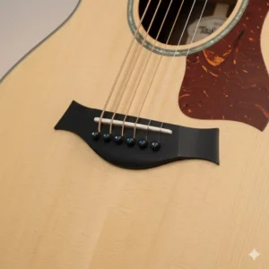 Close-up of the Nubone nut and micarta saddle on the bridge of the Taylor Big Baby guitar.